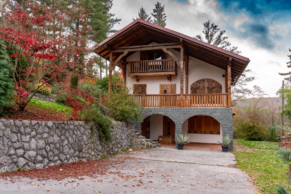 Rustic cabin surrounded by vibrant fall foliage, located in Podgarić, Croatia.