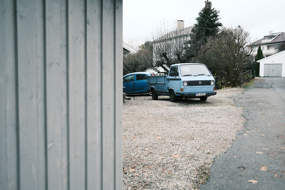 Vintage Volkswagen truck parked in a quiet Oslo suburban neighborhood street.