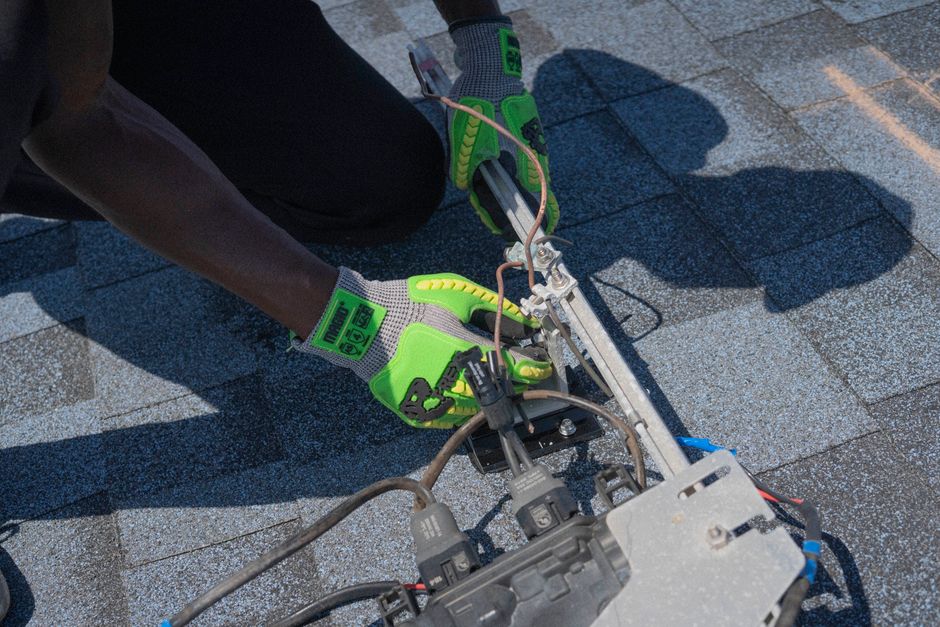 Close-up of a technician working on solar panel installation with green gloves in Tampa, Florida.