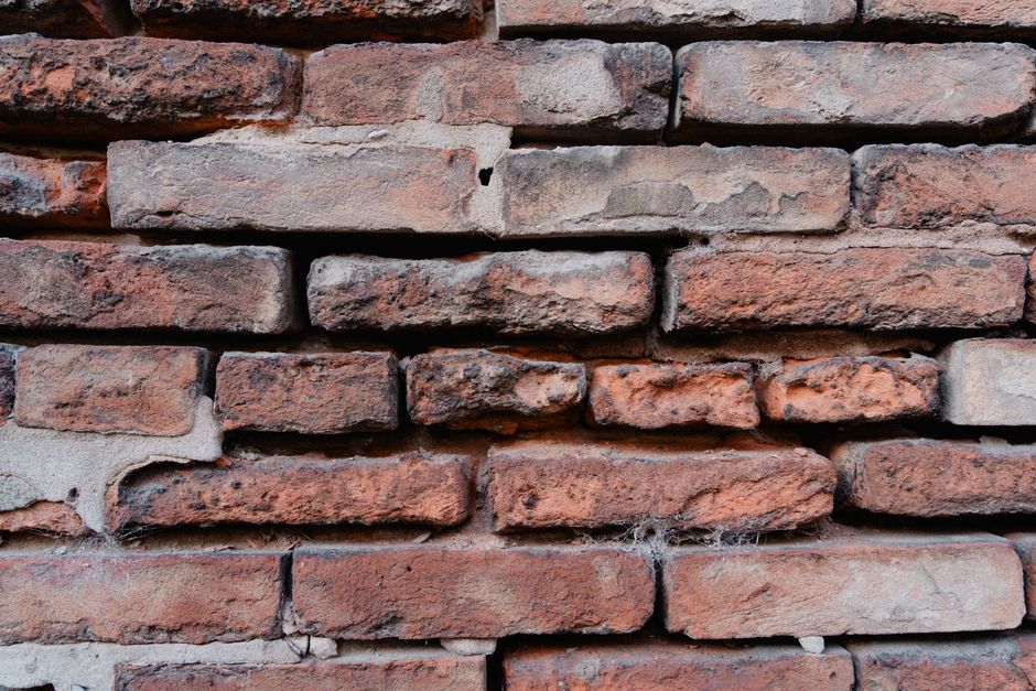 Detailed close-up view of an aged red brick wall showcasing texture and rustic appearance.