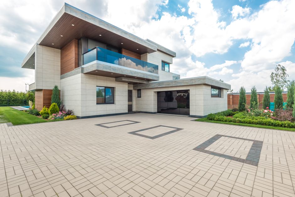 Elegant modern house exterior with lush greenery and ample driveway space.