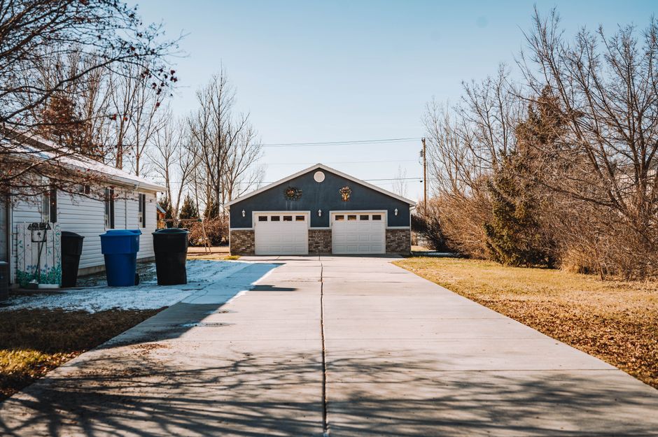 Spacious suburban driveway with house and garage in a peaceful neighborhood setting.