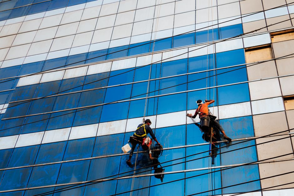 Two window cleaners working on a skyscraper facade in Dhaka, Bangladesh.
