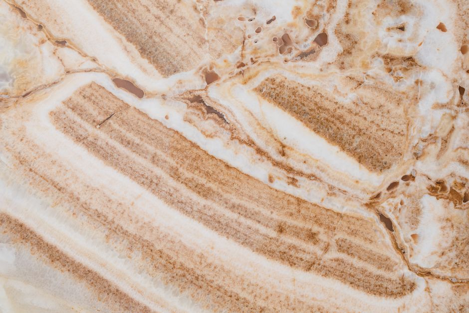 Detailed close-up of brown and white marble texture, showcasing natural cracks and patterns.