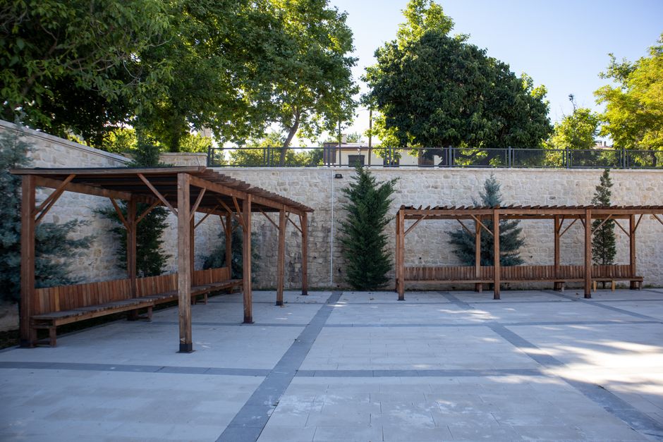 Peaceful outdoor courtyard with wooden pergolas and lush greenery in Elazığ, Türkiye.