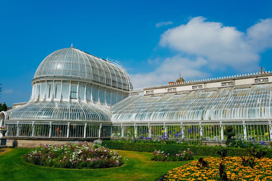 A stunning view of the Palm House in Belfast Botanic Gardens with vibrant floral displays.