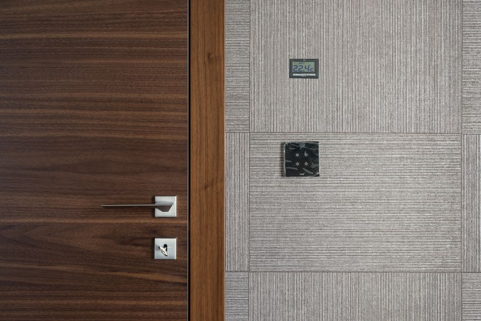 Sleek modern wooden door with stainless steel handle and 22.4°C display.