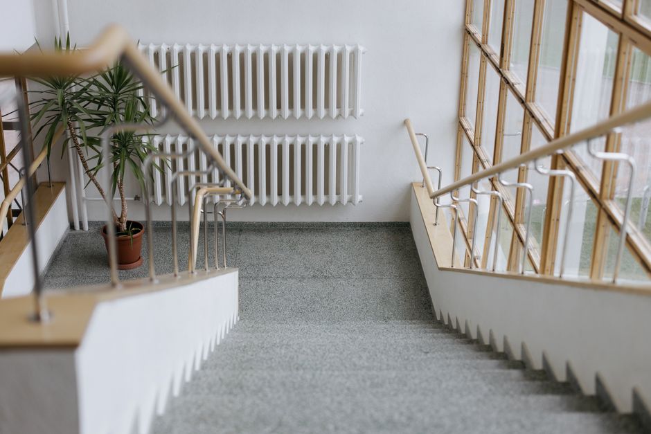 A sleek indoor stairway with modern railings and large windows, offering a minimalist design.