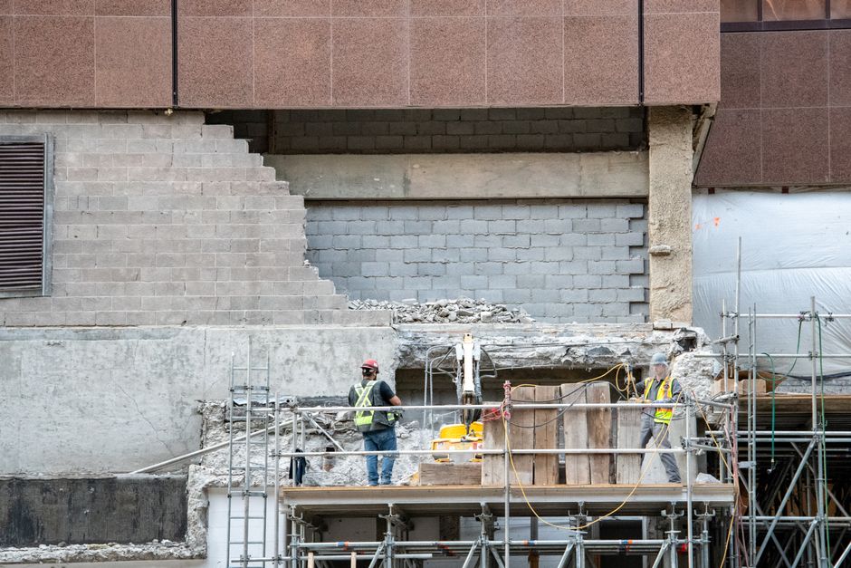 Construction workers on scaffolding at a building site in urban development.