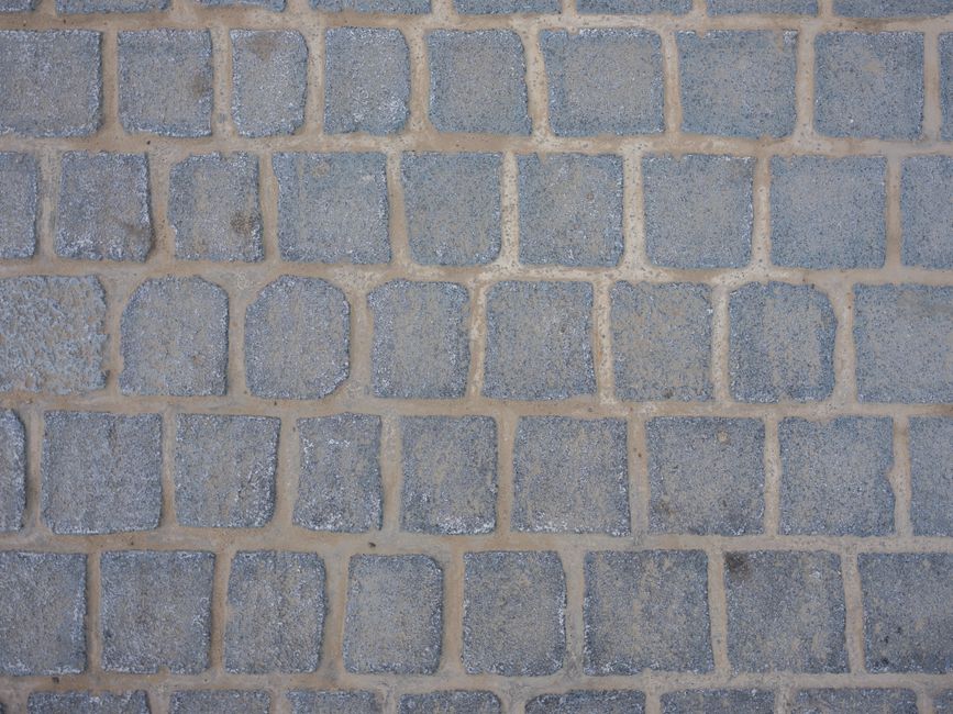 Detailed texture of a weathered cobblestone street surface, ideal for background use.