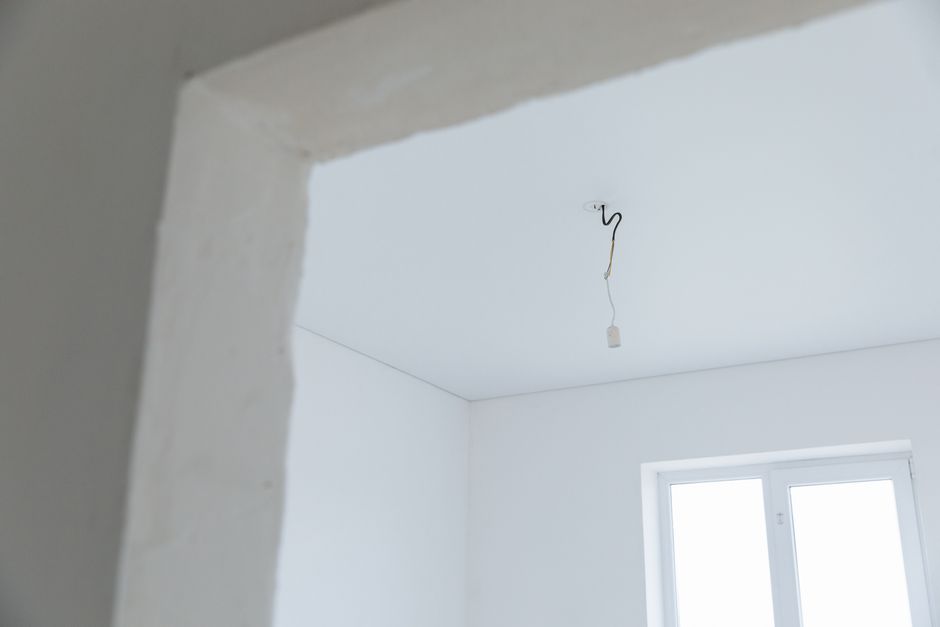 Bright white interior room with exposed electrical wiring and natural light.