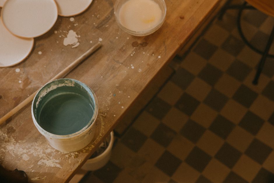 High angle view of paint setup in an artistic studio with wooden table and blue paint.