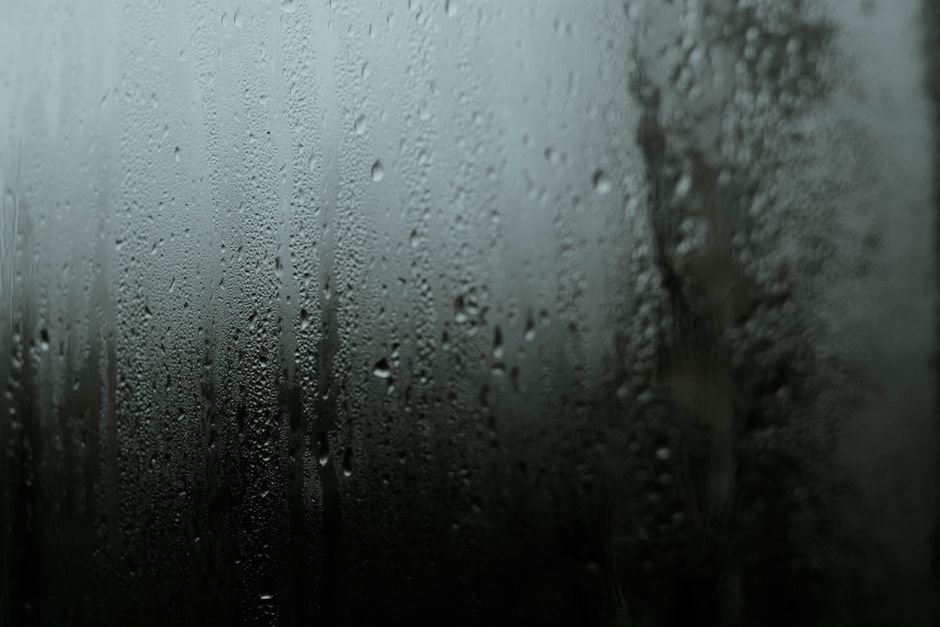 Atmospheric close-up of raindrops on a window, capturing a serene and moody scene.