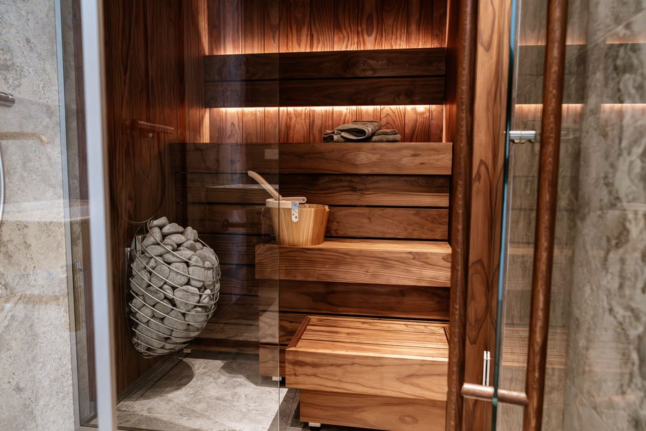 Discover the elegance of a modern indoor sauna featuring sleek wood panels and a glass door.
